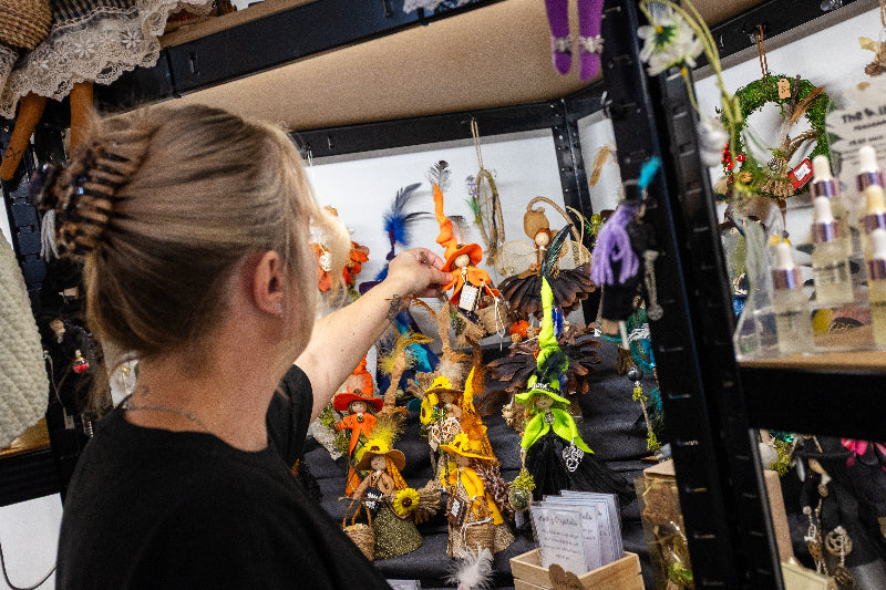 Person interacting with a display of small decorative items in a store.
